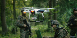 Soldiers in a forest operating a drone.