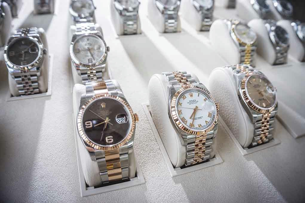 Display of luxury wristwatches on white stands.