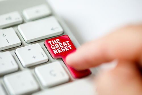 Finger pressing The Great Reset key on keyboard.