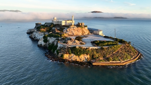 Aerial view of Alcatraz Island surrounded by water and fog