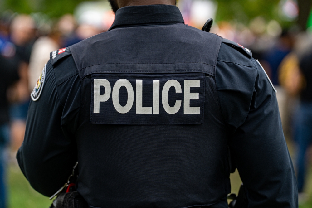 Back view of a police officer in uniform at a public event