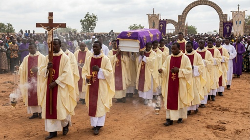 Clergy members in a funeral procession carrying a casket