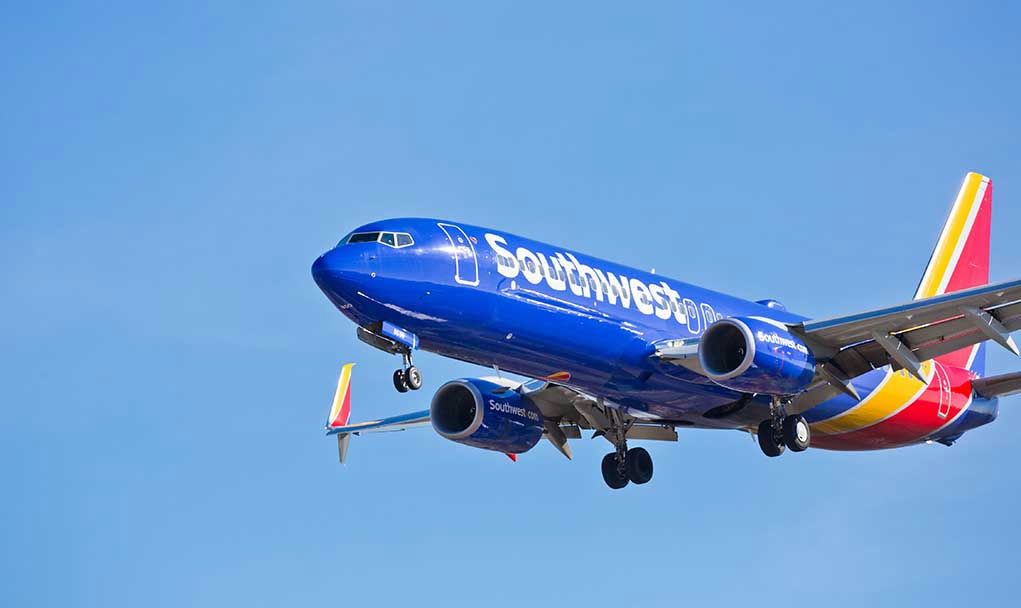 Jet aircraft in flight against clear blue sky.