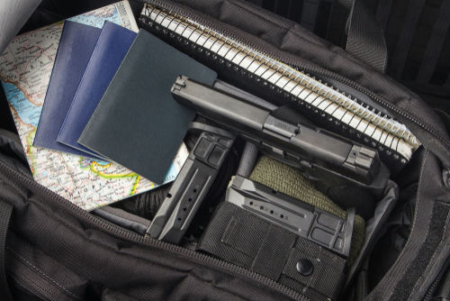 Handgun and magazines in an open travel bag