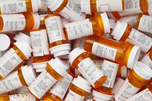 A pile of prescription medication bottles with labels