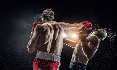 Boxer punches opponent during intense boxing match.