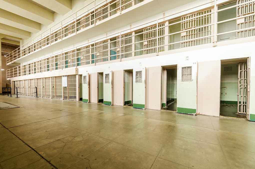 Empty prison cells in a hallway.