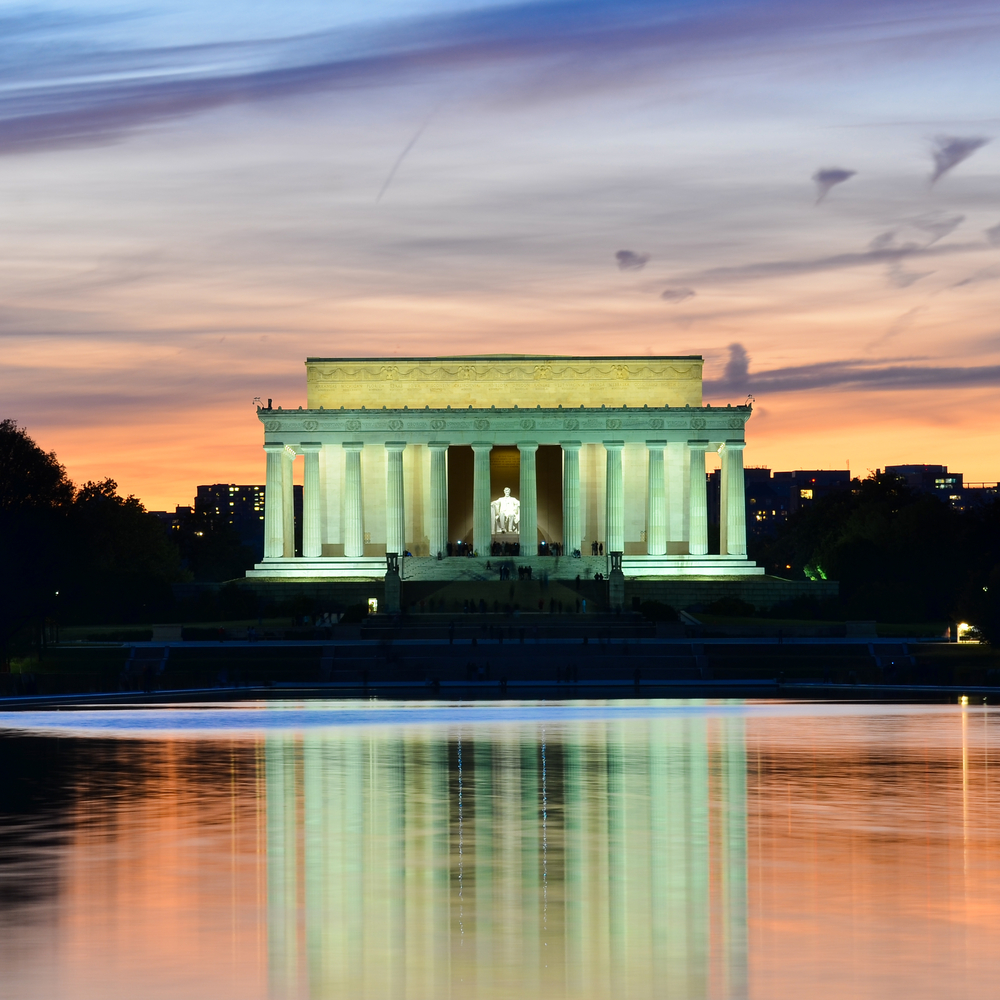Lincoln Memorial illuminated at sunset with reflection in water