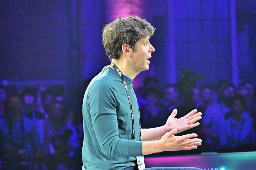 Man speaking on stage with hands gesturing